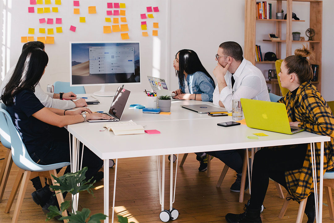 engaged team of employees collaborating around a table with post-it notes